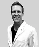 Professional headshot of smiling man in white coat against gray background for Smile Foundation.