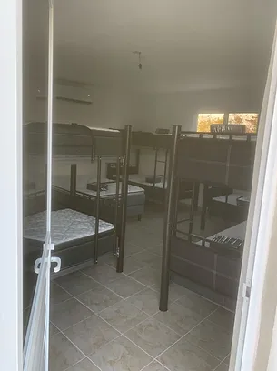 Prison cell with bunk beds and metal bars, institutional detention facility interior