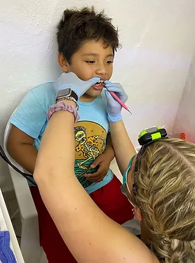 Child receiving dental care or tooth examination from healthcare provider in clinical setting.