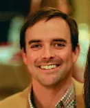 Man smiling at camera in indoor setting, professional headshot for Smile Foundation website.